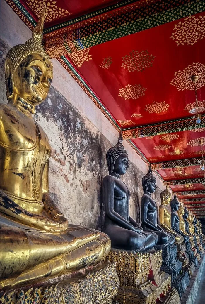 gold and ebony buddha statues in Thai temple