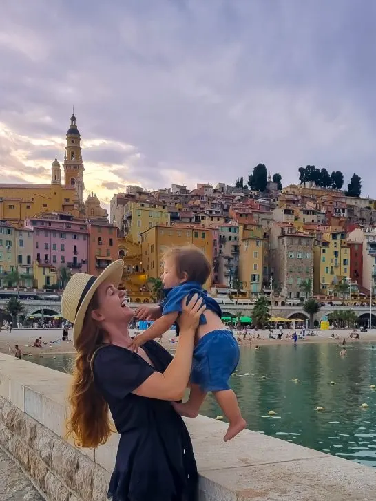 mum holding child at famous menton viewpoint in french riviera